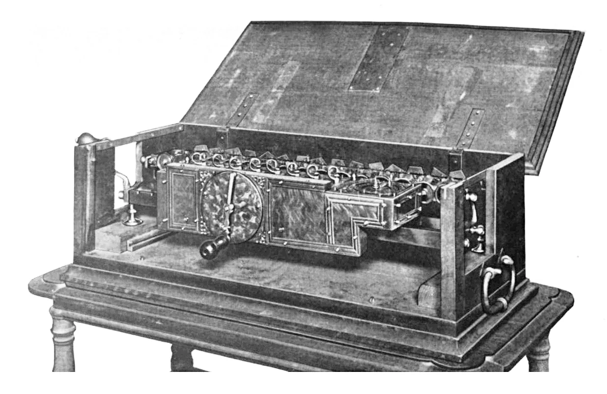 Leibniz's stepped reckoner, a long wooden box of brass gears with the lid open, on a table